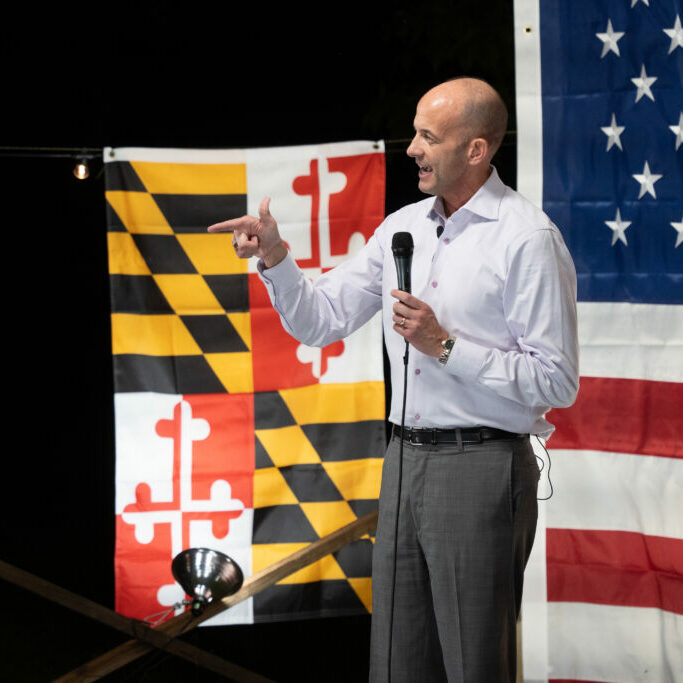 General John Teichert speaking before an American and MD state flag